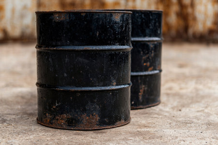 Rusty oil barrels stacked on a wooden surfaceの素材