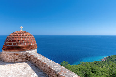 Scenic view of a coastal church with a red dome overlooking the blue mediterranean seaの素材