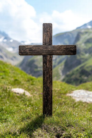 Weathered wooden cross in a grassy mountain landscapeの素材