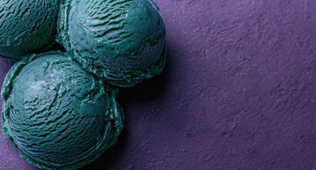 Close-up of dark green ice cream scoops on purple backgroundの素材