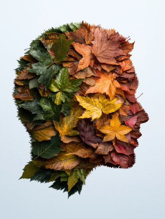 Autumn leaves arranged in the shape of a human head, symbolizing the changing seasons and the passage of time.の素材