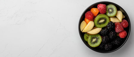 Healthy fruit salad in a black bowl on a white backgroundの素材