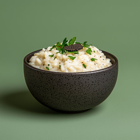 Risotto in ceramic bowl with parsley on green background.の素材