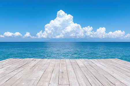 Empty wooden pier overlooking a calm ocean and fluffy cloudsの素材