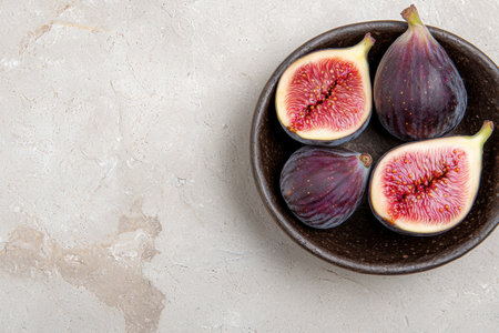 Ripe figs in a rustic bowl on a marble backgroundの素材