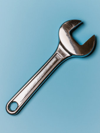 Shiny silver wrench on a light blue backgroundの素材