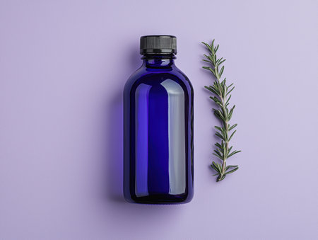 Rosemary essential oil in a blue bottle on purple backgroundの素材