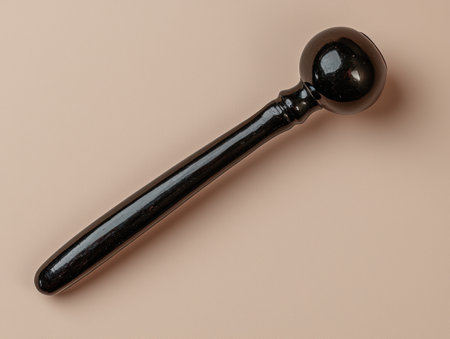 Black wooden massage hammer on beige backgroundの素材