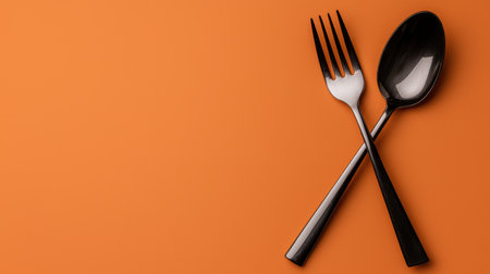 Black cutlery on orange backgroundの素材