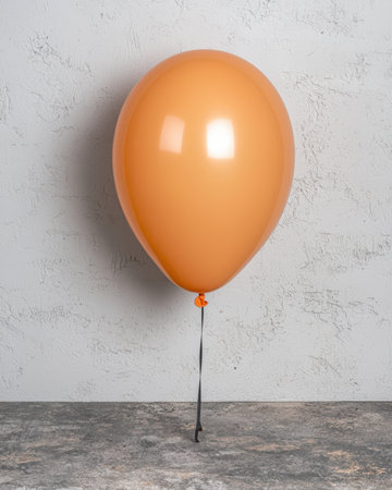 Single orange balloon on grey backgroundの素材