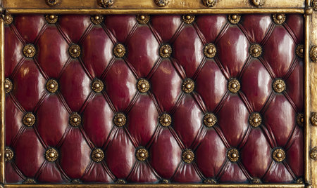 Red leather tufted upholstery with gold accentsの素材