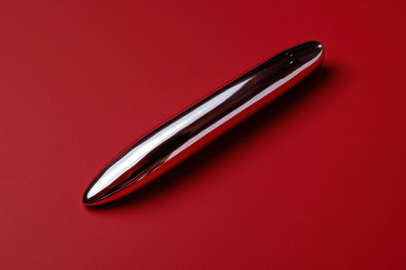 Sleek metallic object on red backgroundの素材