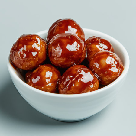 Close-up of glazed meatballs in a white bowlの素材