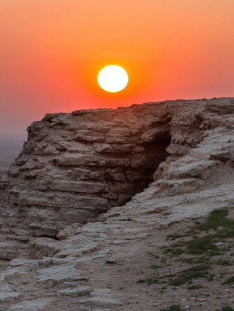 Sunset over rocky landscape with caveの素材