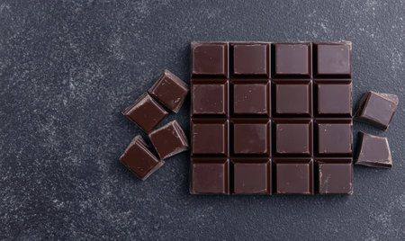 Dark chocolate bar on a dark grey background.の素材