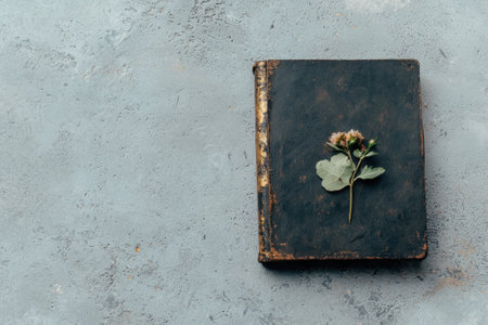 An old book with a flower on a textured background.の素材