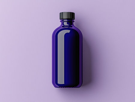 A sleek blue bottle with a black cap on a lavender background.の素材