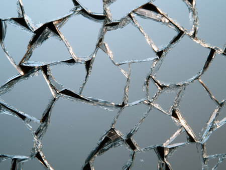Broken mirror pieces reflecting light, creating an abstract pattern.の素材
