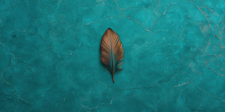 A single feather on a textured teal background.の素材