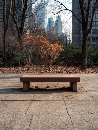 Empty park bench in urban setting during autumn.の素材