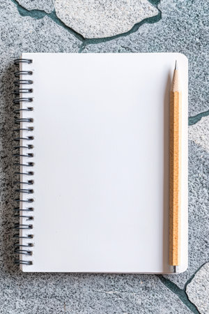 Blank notepad with pencil on stone surface, ready towrite.の素材