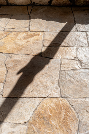 Textured stone wall with abstract shadow pattern.の素材