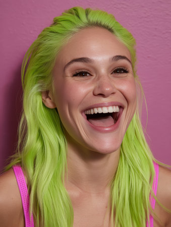 Happy woman with bright green hair laughing cheerfully.の素材