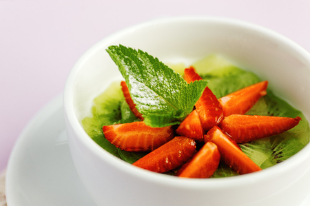 Fresh fruit salad with mint leaves in a bowlの写真素材