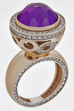 Golden ring with smal diamand stones and big amethyst on white backgroundの写真素材