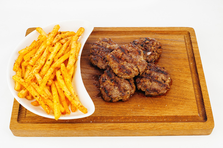 Grilled beef cutlets with french fries on wooden plateの写真素材