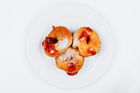 Donuts with jam and icing isolated on white plateの写真素材