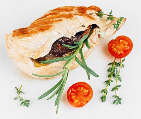 Delicious poultry chicken fillet stuffed with French plums and decorated with tomatoes and herbs