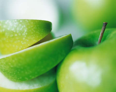 Juicy green apple slices with whole fruit close-up, organic apples agricultural crop from fruit farm, selective focus photograph, positive film scanの写真素材