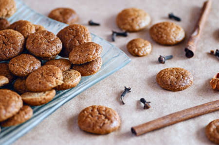 Prepared traditional seasonal round ginger cookies with cloves and cinnamon spices on plate and...