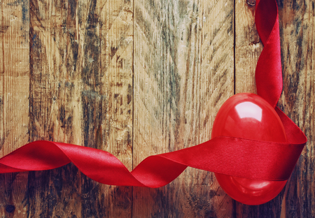Easter background with red ribbon, decorative egg on wooden tableの写真素材