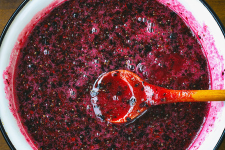cooking homemade jam of black currants, berries with sugar