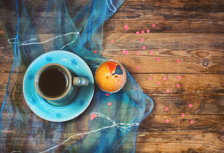 valentine's day, cup of coffee, sweet cake, silk cloth on a wooden table and confetti, retro styleの写真素材