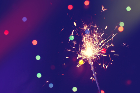 christmas, new year abstract background with sparkler, colorful bokeh, holiday themeの写真素材