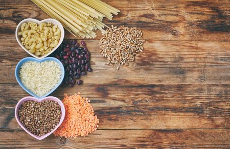 rice, pasta, buckwheat, beans, wheat, grocery products on wooden table, top view, space for textの写真素材