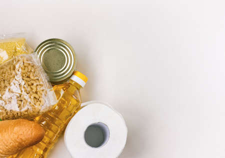 set of necessary products in quarantine period, cereals, bread, sunflower oil, canned food, pasta and toilet paper, gratuitous help, white backgroundの写真素材