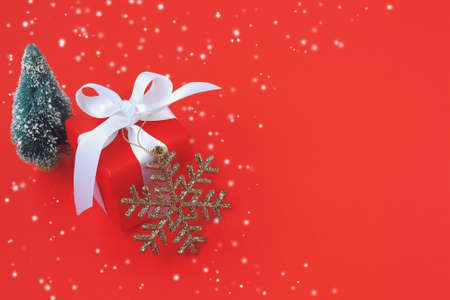 christmas, new year congratulation card, gift, tree and golden snowflake on red paper backgroundの写真素材