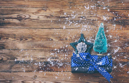 christmas, new year background, star, spruce, silver cone, garland, gift box with  bow on wooden table, vintage style, top viewの写真素材