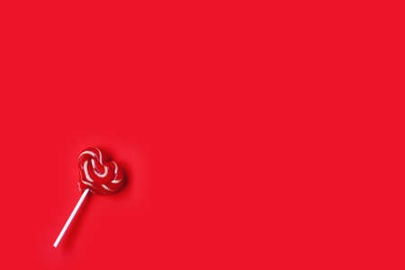 valentine day, striped lollipop shape heart on stick, on red paper background, top view, space for textの写真素材