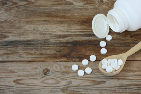 sweetener, stevia in tablets in wooden spoon on table, white jar with sweetener, closeupの写真素材