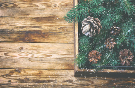 vintage christmas background, wooden box with fir branches, cones on old wooden table, top viewの写真素材