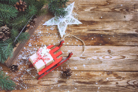new year, christmas background postcard, toy sledge carries gift, wooden table, top view, vintage styleの写真素材