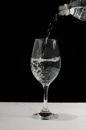 pouring water in wineglassの写真素材