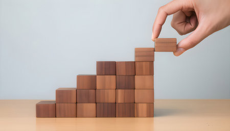 Hand arranging wood block stacking as step stair, business growth concept.の素材