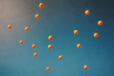 Orange flying balls in the air on a blue background. 3d renderingの素材