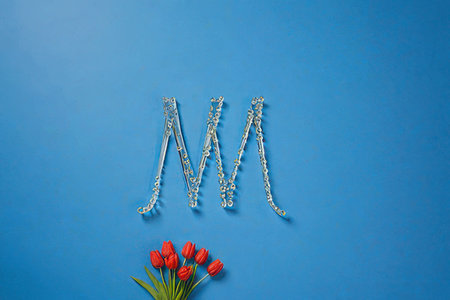 Red tulips and beads on a blue background. Women's Day.の素材
